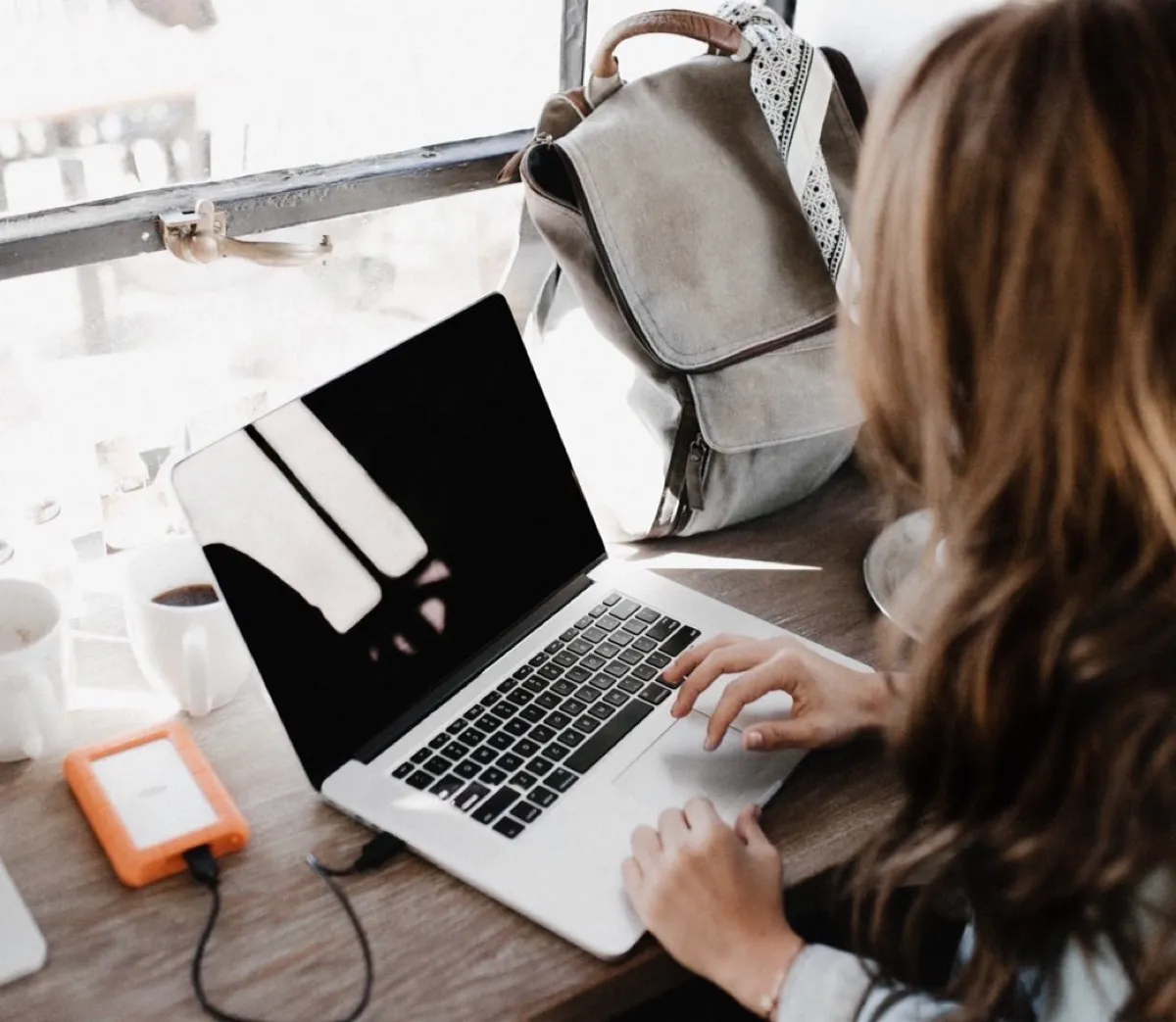 Woman using the laptop by the window
