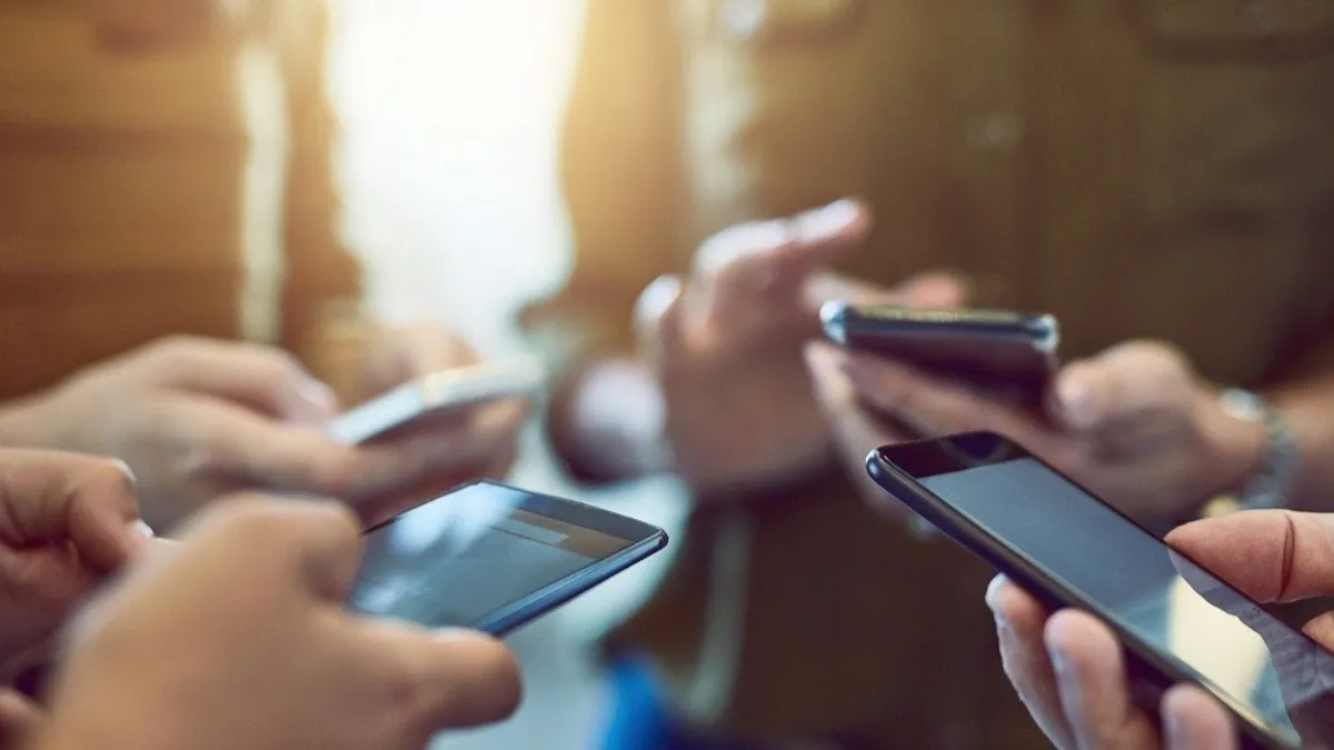 four people using smartphones